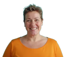 50 jährige Frau mit oragenem Pullover und kurzen brauen Haaren